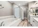 Bright bathroom featuring a soaking tub and a glass-enclosed shower at 3818 S Dallas St, Aurora, CO 80014