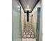 Walk-in shower with vertically mounted shower head and decorative tile floor at 3818 S Dallas St, Aurora, CO 80014