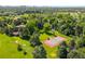 Expansive property featuring a tennis court, putting green, mature trees, and lush lawns against a city skyline at 4181 S Colorado Blvd, Cherry Hills Village, CO 80113