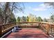 Outdoor deck with wood railings and mature trees, offers a tranquil view of the backyard at 4181 S Colorado Blvd, Cherry Hills Village, CO 80113