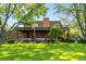 Expansive backyard features a covered patio, brick fireplace, manicured lawn, and mature trees for serene outdoor living at 4181 S Colorado Blvd, Cherry Hills Village, CO 80113