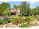 Beautiful red brick home with a lush front garden featuring roses, mature trees, and an elegant garden fountain at 4181 S Colorado Blvd, Cherry Hills Village, CO 80113