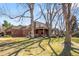 Brick home features a covered patio, well-maintained lawn, mature trees, and seamless outdoor living at 4181 S Colorado Blvd, Cherry Hills Village, CO 80113