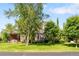 Charming brick home with manicured lawn, mature trees, and outdoor seating area that offers a welcoming curb appeal at 4181 S Colorado Blvd, Cherry Hills Village, CO 80113