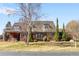 Beautiful home with manicured lawn, classic architecture, light shutters, and mature trees at 4181 S Colorado Blvd, Cherry Hills Village, CO 80113