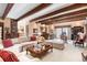 Expansive living room featuring wood beam ceiling, plush seating, and adjoining bar area, perfect for entertaining guests at 4181 S Colorado Blvd, Cherry Hills Village, CO 80113