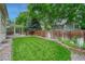 Large backyard with well-maintained grass, privacy fence, mature trees, and patio area at 19149 E Ida Dr, Aurora, CO 80015