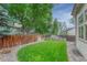 Well-maintained backyard with green grass, privacy fence, and mature trees provides a serene outdoor space at 19149 E Ida Dr, Aurora, CO 80015