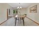 Bright dining room with modern chairs and a wooden table lit by a chandelier underneath an arched ceiling entrance at 19149 E Ida Dr, Aurora, CO 80015