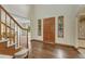 Warm foyer with hardwood floors, staircase, and wooden front door with stained-glass sidelights at 19149 E Ida Dr, Aurora, CO 80015