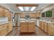 Well-lit kitchen featuring a center island, stainless steel appliances, and light wood cabinetry at 19149 E Ida Dr, Aurora, CO 80015