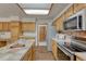 Well-lit kitchen featuring stainless steel appliances and light wood cabinetry at 19149 E Ida Dr, Aurora, CO 80015