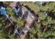 Overhead view of the house, nestled within a dense forest, surrounded by mature trees, and a private driveway at 20606 Yoke Trl, Morrison, CO 80465