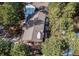 Overhead view showcasing a house's layout, nestled amongst dense trees, with a spacious deck perfect for outdoor living at 20606 Yoke Trl, Morrison, CO 80465