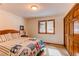 Bright bedroom features a comfortable bed with a colorful quilt, a window, and a closet at 20606 Yoke Trl, Morrison, CO 80465