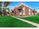 Brick apartment building with multiple balconies and a well-manicured lawn at 3613 S Sheridan Blvd # 11, Denver, CO 80235