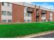 Attractive brick apartment building showcasing private balconies and lush green lawn at 3613 S Sheridan Blvd # 11, Denver, CO 80235