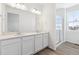 Bright bathroom featuring double sinks, quartz countertop, and a glass-enclosed shower at 6554 N Malta St, Aurora, CO 80019