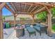 Relaxing backyard pergola with comfortable seating, fire pit, and view of the yard at 9446 W Wagon Trail Cir, Littleton, CO 80123