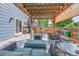 Inviting backyard patio under a wooden pergola with comfortable seating and a fire pit at 9446 W Wagon Trail Cir, Littleton, CO 80123
