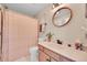 Charming bathroom featuring a decorative shower curtain and round mirror above the vanity at 9446 W Wagon Trail Cir, Littleton, CO 80123