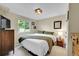 Comfortable bedroom with natural light, wooden dresser, and bedside table with lamp at 9446 W Wagon Trail Cir, Littleton, CO 80123