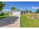 Charming blue home with a well-manicured lawn and a convenient two-car garage at 9446 W Wagon Trail Cir, Littleton, CO 80123