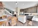 Modern kitchen with a white island, dark cabinets, and an adjacent dining area at 9446 W Wagon Trail Cir, Littleton, CO 80123