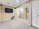 Finished basement with neutral carpeting, a TV, and a doorway leading to other rooms at 9867 Mulberry Way, Highlands Ranch, CO 80129