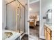 Bathroom with a glass-enclosed shower, a tub, and a peek into the bedroom area at 9867 Mulberry Way, Highlands Ranch, CO 80129
