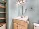 Bright bathroom with light wood vanity, oval mirror, and storage shelves at 9867 Mulberry Way, Highlands Ranch, CO 80129