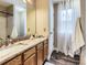 Well-lit bathroom featuring a granite countertop, wood cabinets, and a shower/tub combination at 9867 Mulberry Way, Highlands Ranch, CO 80129