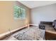 Cozy living room featuring wood flooring, a modern rug, and a large window for natural light at 9867 Mulberry Way, Highlands Ranch, CO 80129