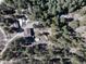 Aerial view of home on a wooded lot with circular driveway and multiple structures at 24949 N Mountain Park Dr, Evergreen, CO 80439