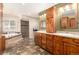 Spacious bathroom featuring a soaking tub, shower, and dual sink vanity with beautiful wood cabinetry at 24949 N Mountain Park Dr, Evergreen, CO 80439