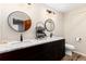 Bathroom with dual sinks, modern fixtures, and dark wood cabinets at 24949 N Mountain Park Dr, Evergreen, CO 80439