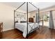 Comfortable bedroom with hardwood floors, neutral walls, and slider to the outside at 24949 N Mountain Park Dr, Evergreen, CO 80439