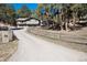 Charming home with a split rail fence, a long driveway, and a two-car garage at 24949 N Mountain Park Dr, Evergreen, CO 80439