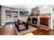 A cozy living room with a stone fireplace, sliding glass doors to the backyard, and comfortable leather furniture at 24949 N Mountain Park Dr, Evergreen, CO 80439
