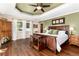 Main bedroom suite featuring tray ceilings, hardwood floors, and large windows at 24949 N Mountain Park Dr, Evergreen, CO 80439
