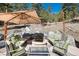 Outdoor stone patio featuring a fire pit, comfortable seating and a large umbrella to provide shade on sunny days at 24949 N Mountain Park Dr, Evergreen, CO 80439