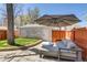 Private backyard with a stone patio, modern outdoor furniture, and a lush green lawn at 4551 Julian St, Denver, CO 80211
