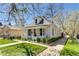 Well-maintained brick home featuring a quaint front porch and a beautifully landscaped lawn at 4551 Julian St, Denver, CO 80211