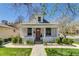 Charming brick home with a cozy front porch, stone walkway, and lush, landscaped yard at 4551 Julian St, Denver, CO 80211