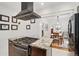 This kitchen has an island with cooking and views of the connected rooms and dark cabinets at 4551 Julian St, Denver, CO 80211