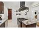 This kitchen has dark cabinets and stainless steel appliances with a cooking island and views to other rooms at 4551 Julian St, Denver, CO 80211
