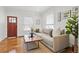 Inviting living room featuring a neutral sofa, hardwood floors, and a view of the front yard at 4551 Julian St, Denver, CO 80211