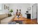 Spacious living room with hardwood floors, a comfortable sofa, and an open view to the dining area at 4551 Julian St, Denver, CO 80211