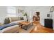 Open-concept living room with hardwood floors, neutral-toned sofa, and a view into the dining area at 4551 Julian St, Denver, CO 80211