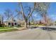 Charming home with front yard framed by a large tree in residential neighborhood at 4551 Julian St, Denver, CO 80211